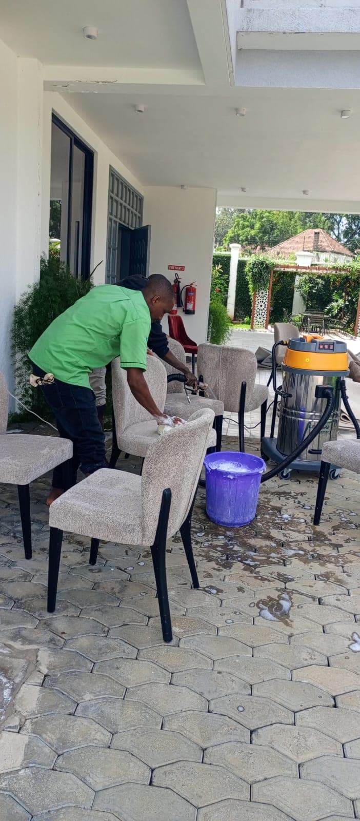 Technician shampooing dining chair upholstery with a Karcher extraction machine